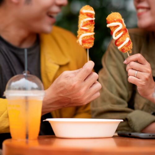 Front view smiley couple with corn dogs 2